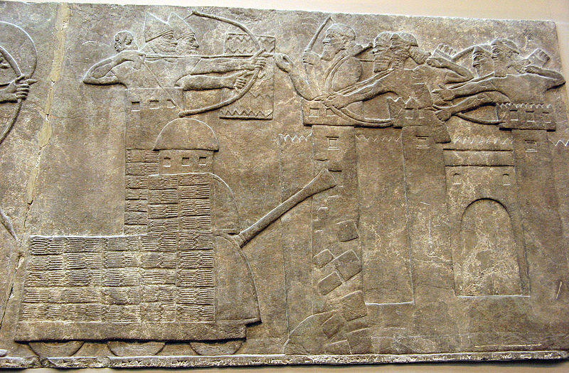 Assyrian attack on a town with archers and a wheeled battering ram ; Assyrian Relief, North-West Palace of Nimrud (British Museum)